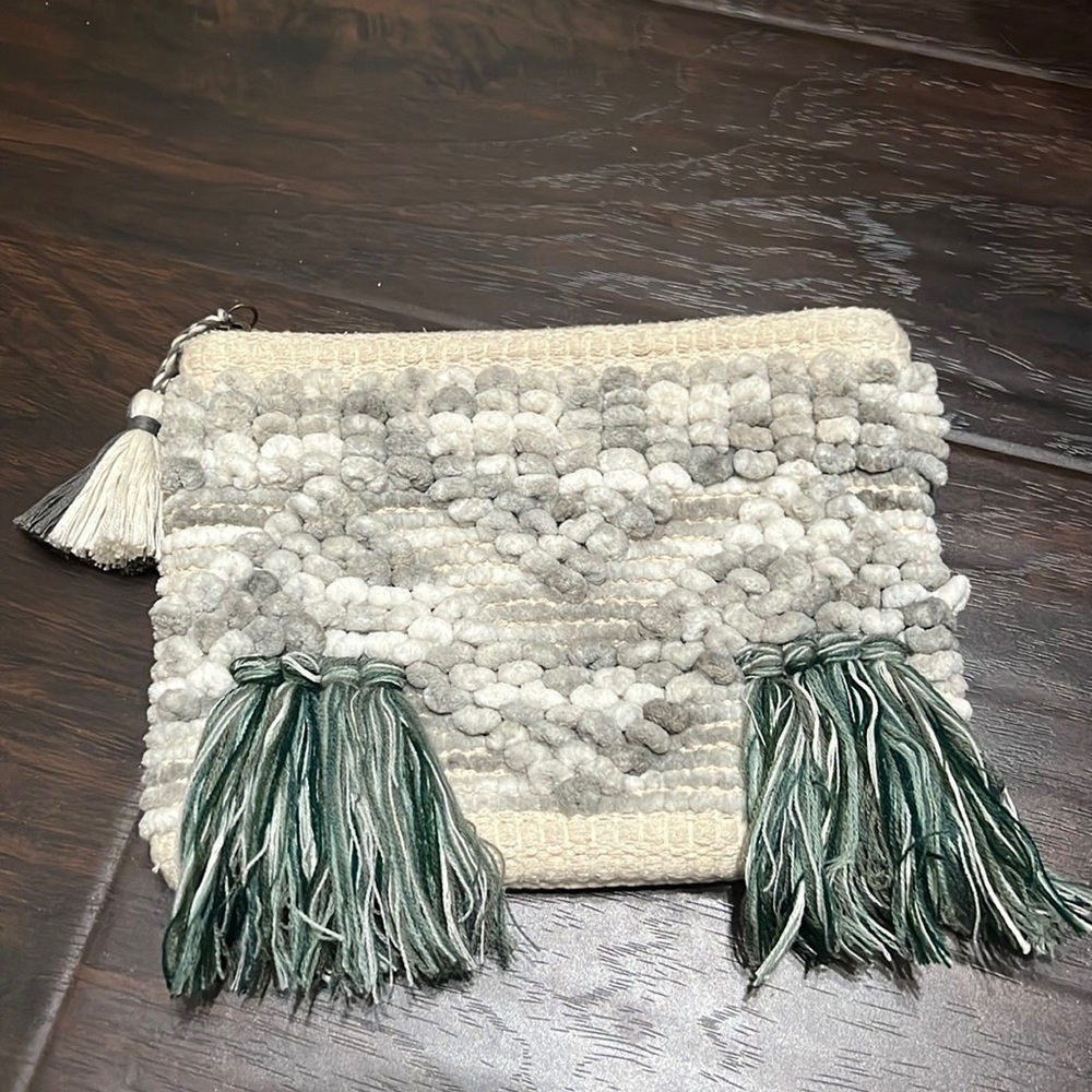 Gray pom pom and tassel clutch with zipper closure
